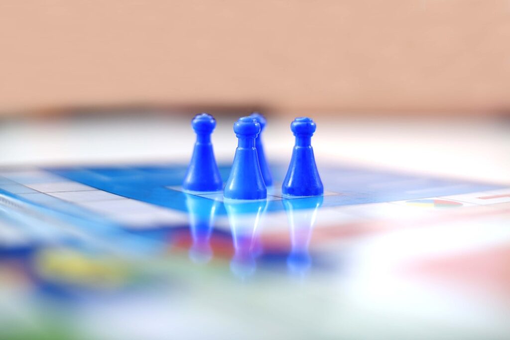 Close-up of four blue pawns placed on a Ludo game board, reflecting vibrant colors and a clean, blurred background.